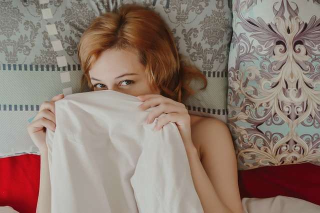 ベッドで恥ずかしがっている女性
